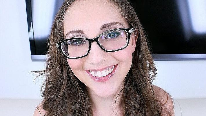 Una chica seductora y sonriente con gafas chupa tu alma en sus ojos